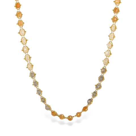 A moonstone chain necklace with varying hues of orange, cream, and gray, stones strung on an 18k yellow gold chain.