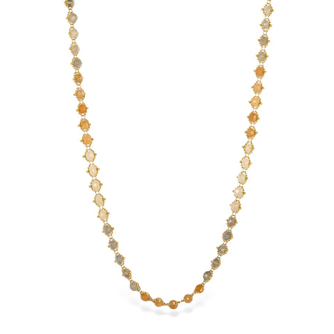 A moonstone chain necklace with varying hues of orange, cream, and gray, stones strung on an 18k yellow gold chain.