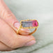 Gold ring with a watermelon tourmaline gemstone on a blurred background