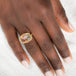 Gold ring with sunstone gemstone on a person's finger