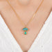Gold necklace with a mushroom pendant on a person