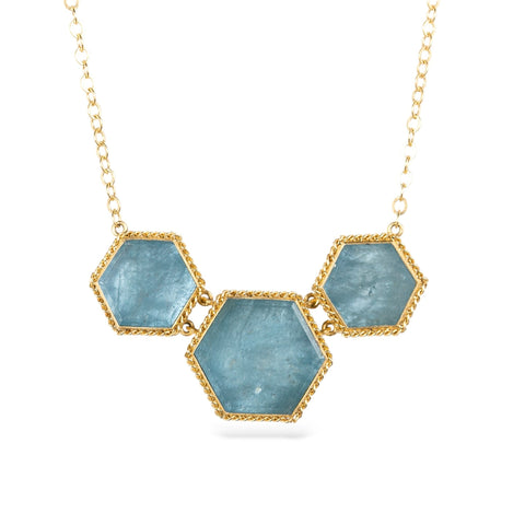 Necklace with hexagonal aquamarine stones and gold accents on a white background