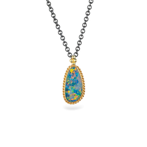 Australian opal doublet necklace with 18k gold bezel and oxidized silver chain, against a white background.