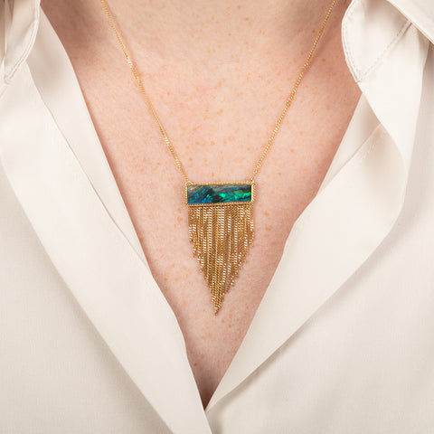 Australian opal doublet necklace with a gold fringe tassel on a person
