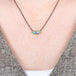 Australian opal gemstone necklace with a gold setting and oxidized silver chain on a person