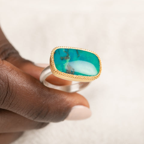 Gold and silver ring with gem silica gemstone held in hand