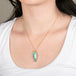 Blue opal petrified wood pendant necklace with gold setting on a person