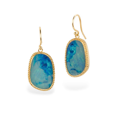 Gold earrings with blue australian opal gemsotnes on white background