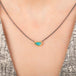 Handmade necklace featuring a boulder opal stone set in an 18k gold bezel and paired with an oxidized silver chain, worn on a person's neck.