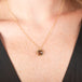 Necklace with a natural brown diamond set in a handmade gold bezel on a person