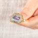 A close up of a person holding a handmade fine jewelry amethyst gemstone ring set in 18k gold with a sterling silver band