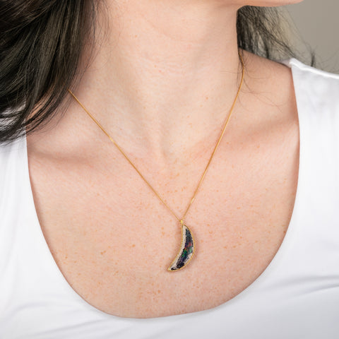 Handcrafted Mexican Opal pendant necklace with a gold setting on a person.