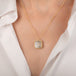 Gold necklace featuring a dendritic stone worn on a model's neck.