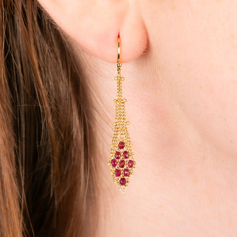 Drop earrings featuring a latticework of 18k gold chain that leads to a section of red ruby beads in a kite shape.