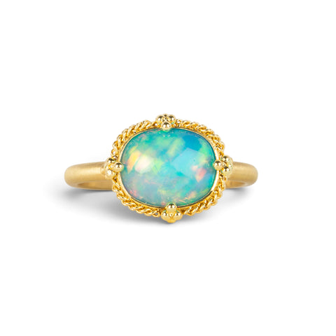 Gold ring featuring a vibrant Ethiopian opal stone, set against a white background.