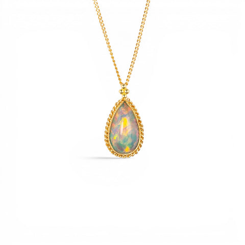 A gold teardrop-shaped Ethiopian Opal necklace shown against a white backdrop.