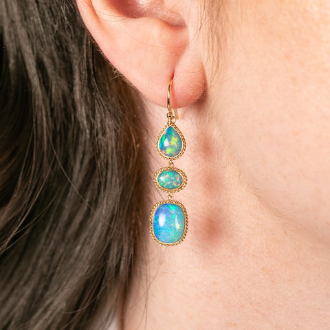 Handcrafted ethiopian opal earrings set in gold worn on a model