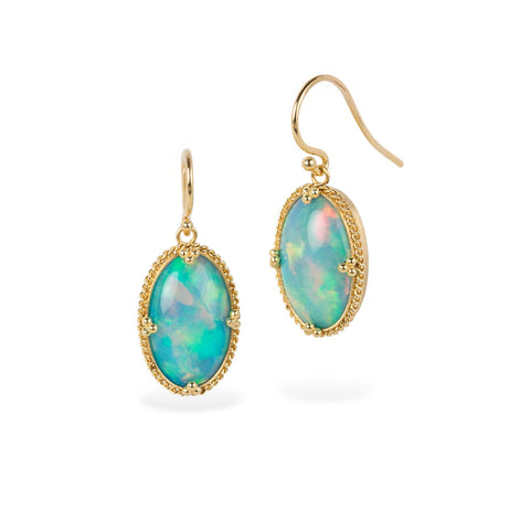 Pair of gold earrings with ethiopian opal stones on a white background