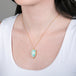 Ethiopian opal pendant necklace with 18k gold bezel on a person