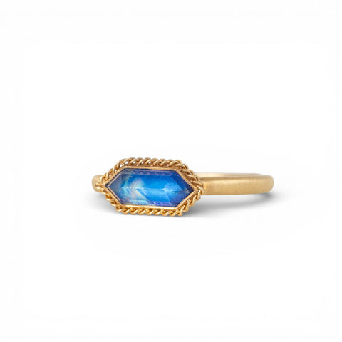 Gold ring with a moonstone on a white background