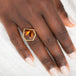 Ring with a tourmaline gemstone on a hand against a white background