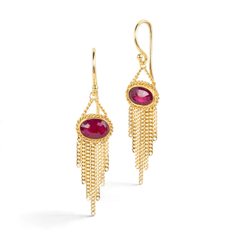 Gold earrings featuring oval rhodolite garnet gemstones, shown against a white background.