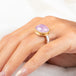 A gold and silver ring featuring a pink kunzite stone, worn on a person's finger