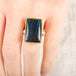 Close up of a person wearing a handmade fine jewelry labradorite ring set in 18k gold with a sterling silver band