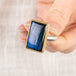 Close up of a person holding a handmade fine jewelry labradorite ring set in 18k gold with a sterling silver band