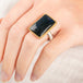 Close up of a person wearing a handmade fine jewelry labradorite ring set in 18k gold with a sterling silver band