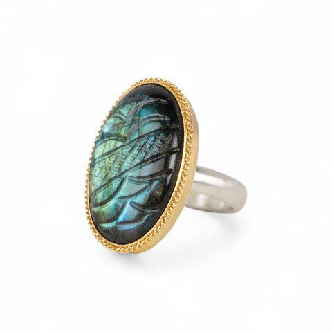 Handmade fine jewelry labradorite ring with carved design set in 18k gold with a sterling silver band