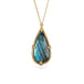 Gold necklace featuring a teardrop-shaped labradorite pendant on a gold chain against a white background.