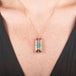Handmade necklace with a watermelon tourmaline gemstone set in a gold bezel on a person