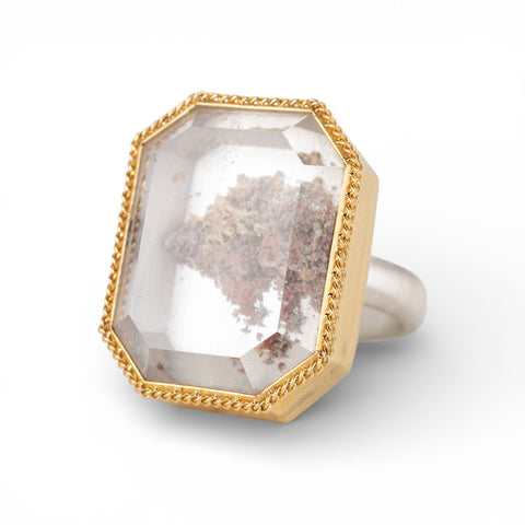 Ring with handmade gold frame and sterling silver band featuring a lodolite quartz stone on a white background
