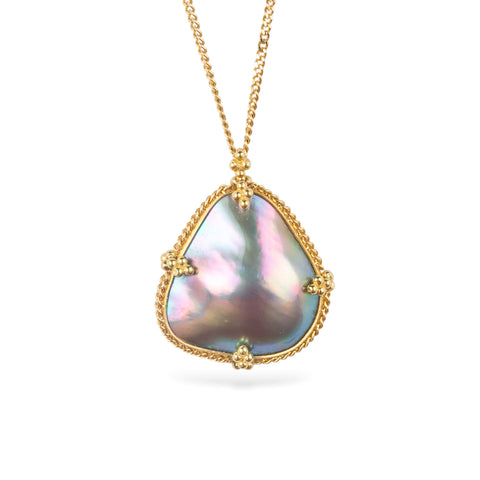 Gold necklace featuring a mabe pearl stone against a white background
