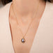 Gold necklace featuring a mabe pearl set in a handcrafted 18k gold bezel, worn on a person's neck.