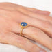 Gold ring with a moonstone on a hand against a white background