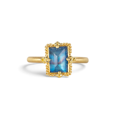 A gold ring featuring a rectangular moonstone set in a 18k gold bezel, against a clean white background.