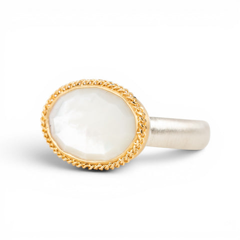 Gold and silver ring with a mother of pearl on a white background
