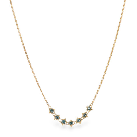 18k yellow gold chain necklace featuring a row of seven blue diamonds in the center.