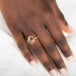 Gold ring with a sunstone on a person's finger