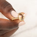 Gold ring with a sunstone held in hand