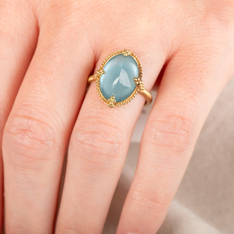 A model wears a handmade aquamarine gemstone and 18k yellow gold ring.