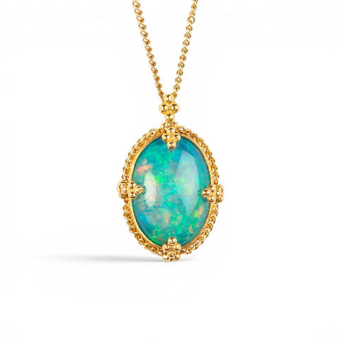 A gold necklace featuring an oval Ethiopian opal gemstone, shown against a white backdrop.