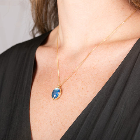 Handmade gold necklace with a moonstone pendant in an 18k gold bezel on a person
