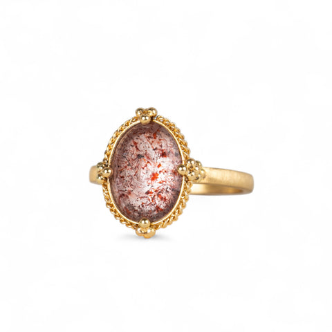 Handmade 18k gold ring featuring a Super 7 gemstone on a white background.