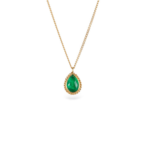 Gold necklace with a petite emerald gemstone set in a handmade gold bezel on a white background.