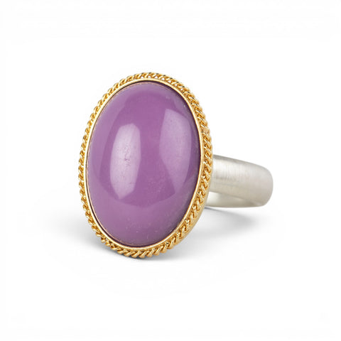 A gold and silver ring with a purple phosphosiderite stone, shown against a white background.