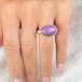 A gold and silver ring featuring a phosphosiderite stone, worn on a person's finger.