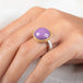 A gold and silver ring featuring a phosphosiderite stone, worn on a person's finger.